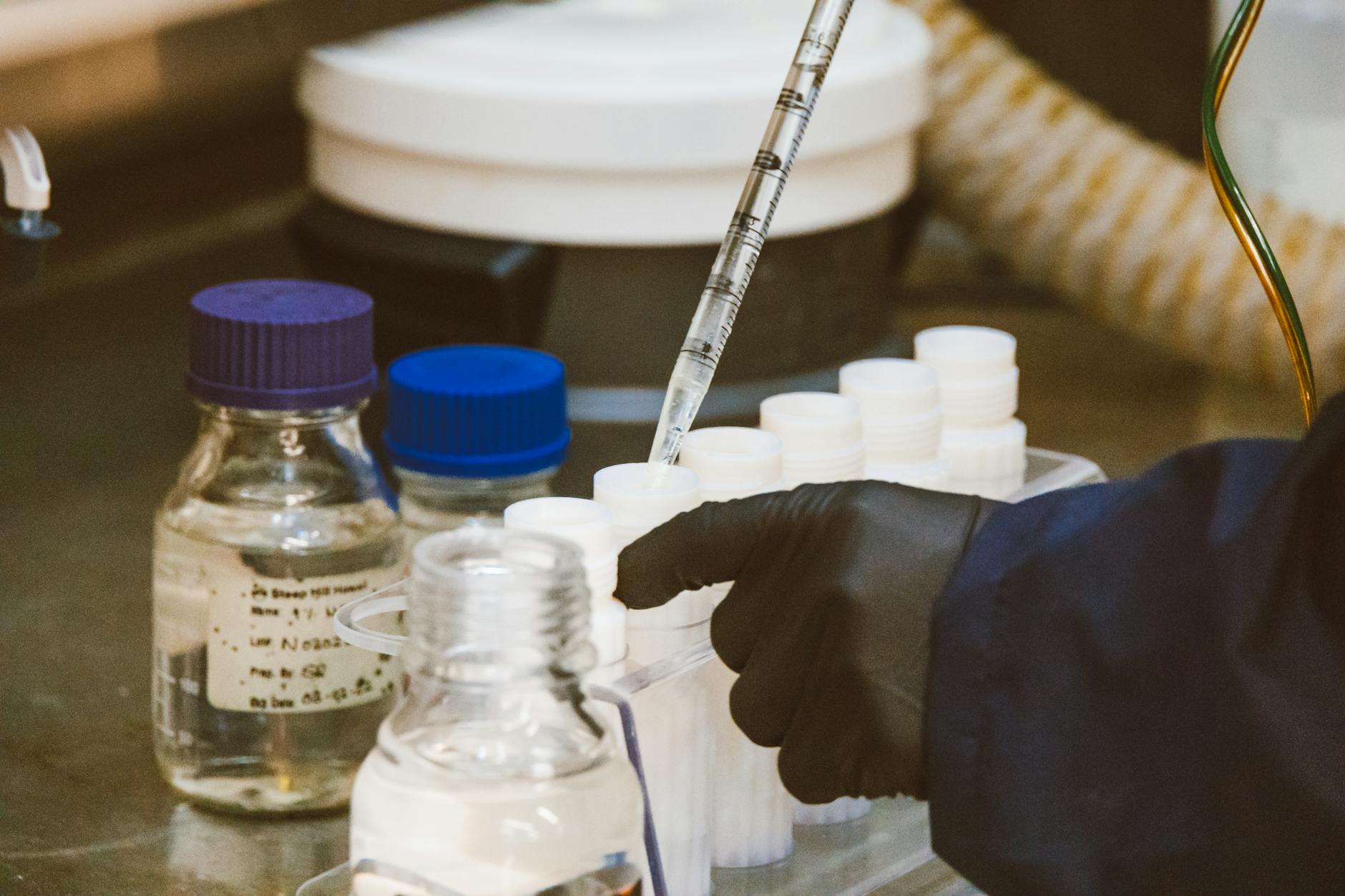 Laboratory glass vials and pipette on a benchtop — NAD+ and NMN research workflow