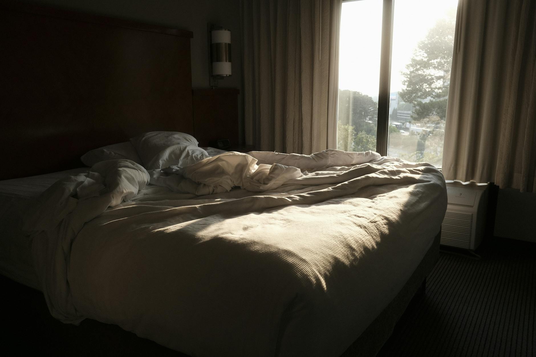 Bedroom in morning light with rumpled linen — sleep recovery growth hormone